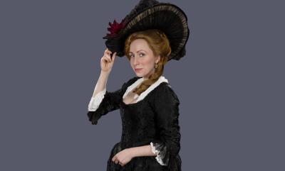 Lady Susan in a black Georgian gown and hat