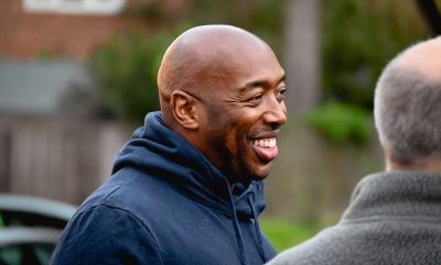 A Man Smiling Whilst Talking To Friends