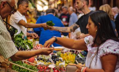 Saturday Market at The Shed woman paying for produce with other people in the background