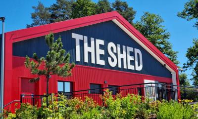 The front of The Shed with trees and bushes