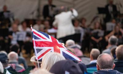 A Union Jack being waved with a conductor in the background