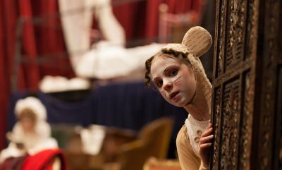 Girl in mouse costume learning out from a wardrobe