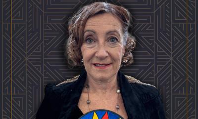 Clarice Cliff holding a brightly patterned plate