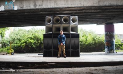 A man standing in front of some speakers