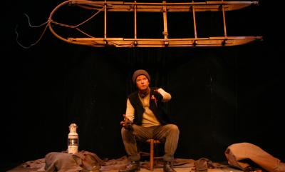 A man sat telling a story with snow gear around him