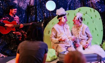 Two people dressed as sheep and a guitarist