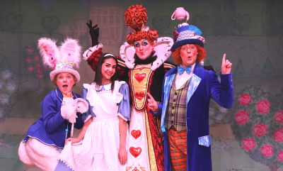 The cast of Alice in Wonderland: a person wearing bunny ears, a girl in a blue and white dress, the Queen of Hearts and the Mad Hatter