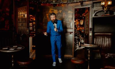 A man in a blue suit in an empty pub