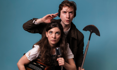 A man with a headset and shovel and a woman with a microphone