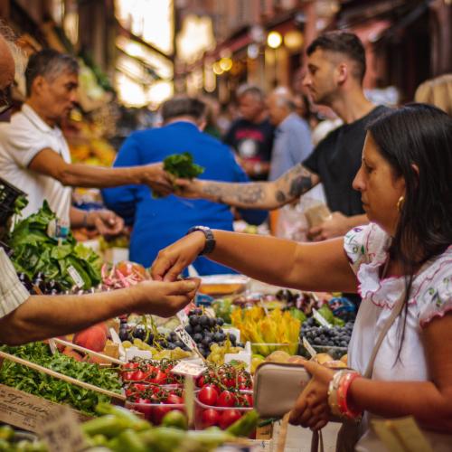 Saturday Market at The Shed woman paying for produce with other people in the background